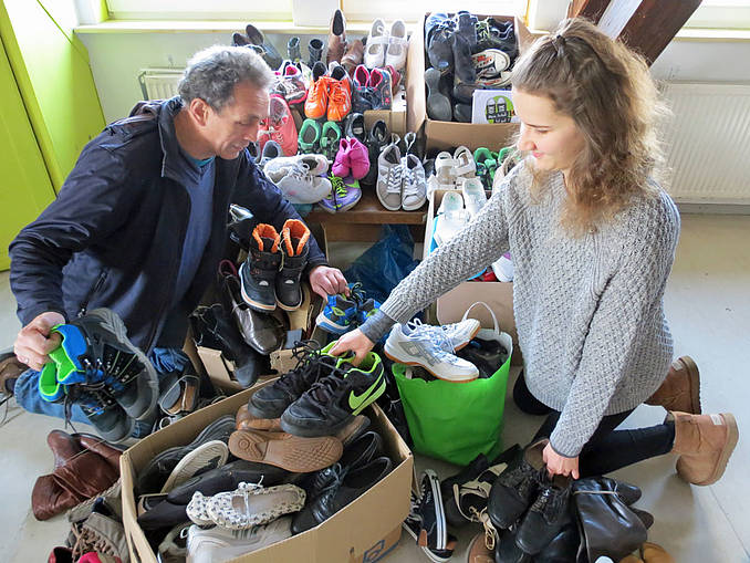 Alfred Nisch und  Marissa Digeser (KF Ergenzingen) sortieren Schuhe. Bild: Claudia Hofrichter